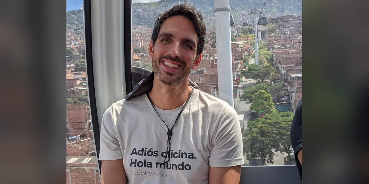 Daniel Matesa con la camiseta «Adiós oficina. Hola mundo» de DigiNomadas en el teleférico de Medellín